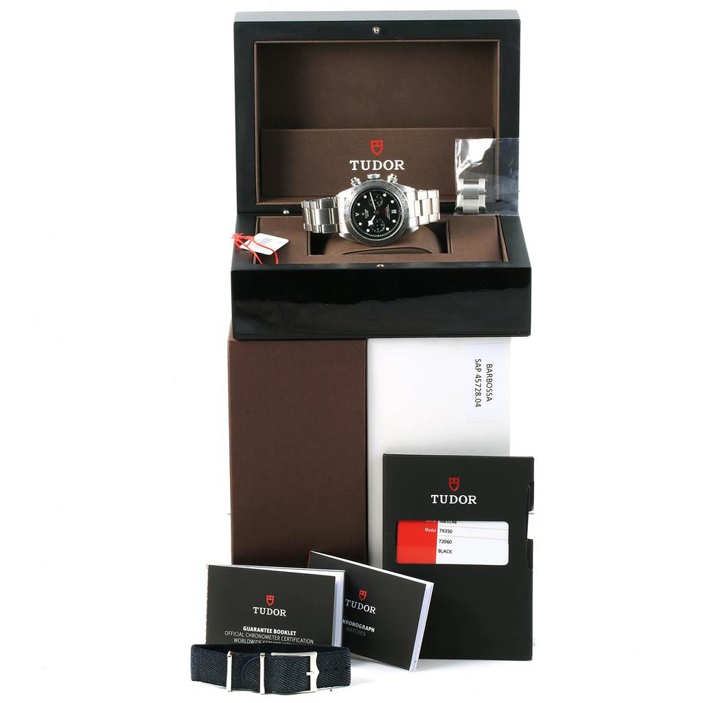 The image shows the Tudor Heritage Black Bay 79350 Men's Stainless Steel Black Dial 79350 Men's Stainless Steel Black Dial watch with its metal strap and box, manual, guarantee booklet, and fabric strap accessories.