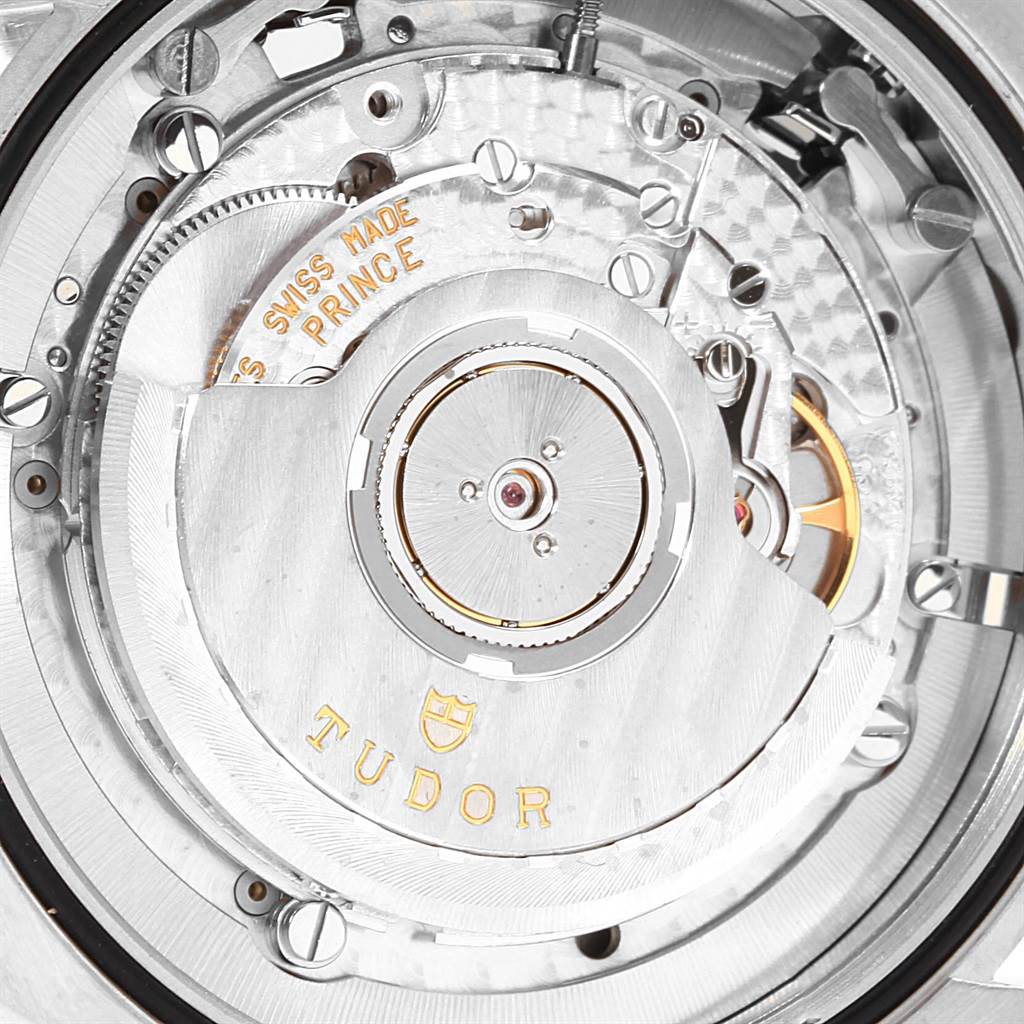 The image shows a close-up rear view of the Tudor Heritage Chrono 70330 Men's Stainless Steel Blue Dial 70330 Men's Stainless Steel Blue Dial watch, highlighting its intricate movement mechanics.