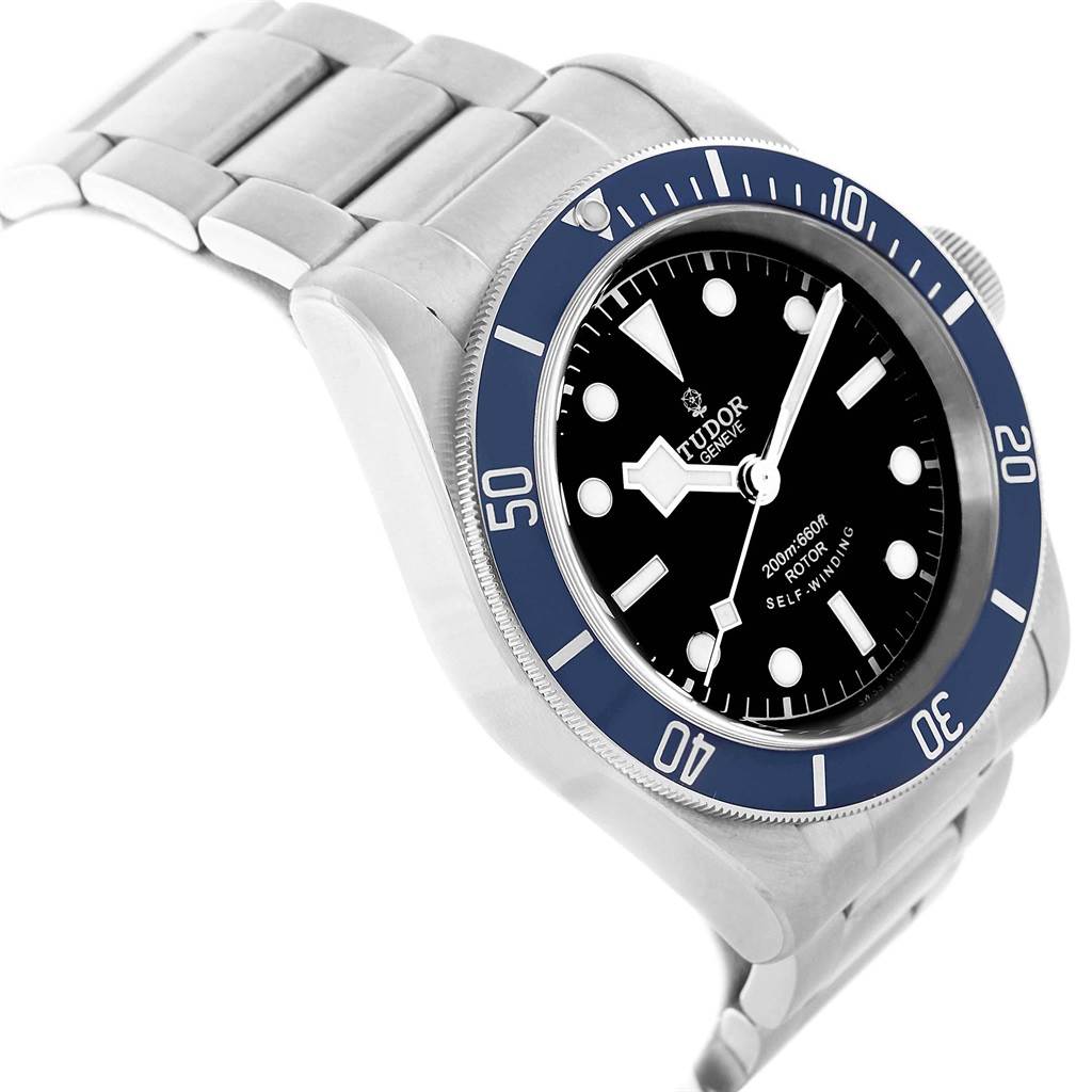 This image shows a Tudor Heritage Black Bay 79220B Men
s Stainless Steel Black Dial 79220B Men
s Stainless Steel Black Dial watch at a three-quarter angle, highlighting the face, bezel, and part of the bracelet.
