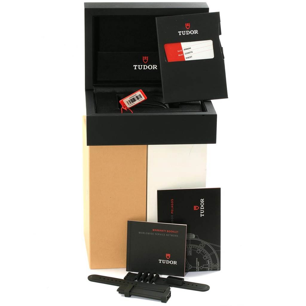 The image shows the packaging and accessories for a Tudor Pelagos 25500TN Men's Titanium Black Dial 25500TN Men's Titanium Black Dial watch, including manuals, warranty card, strap, and watch box.