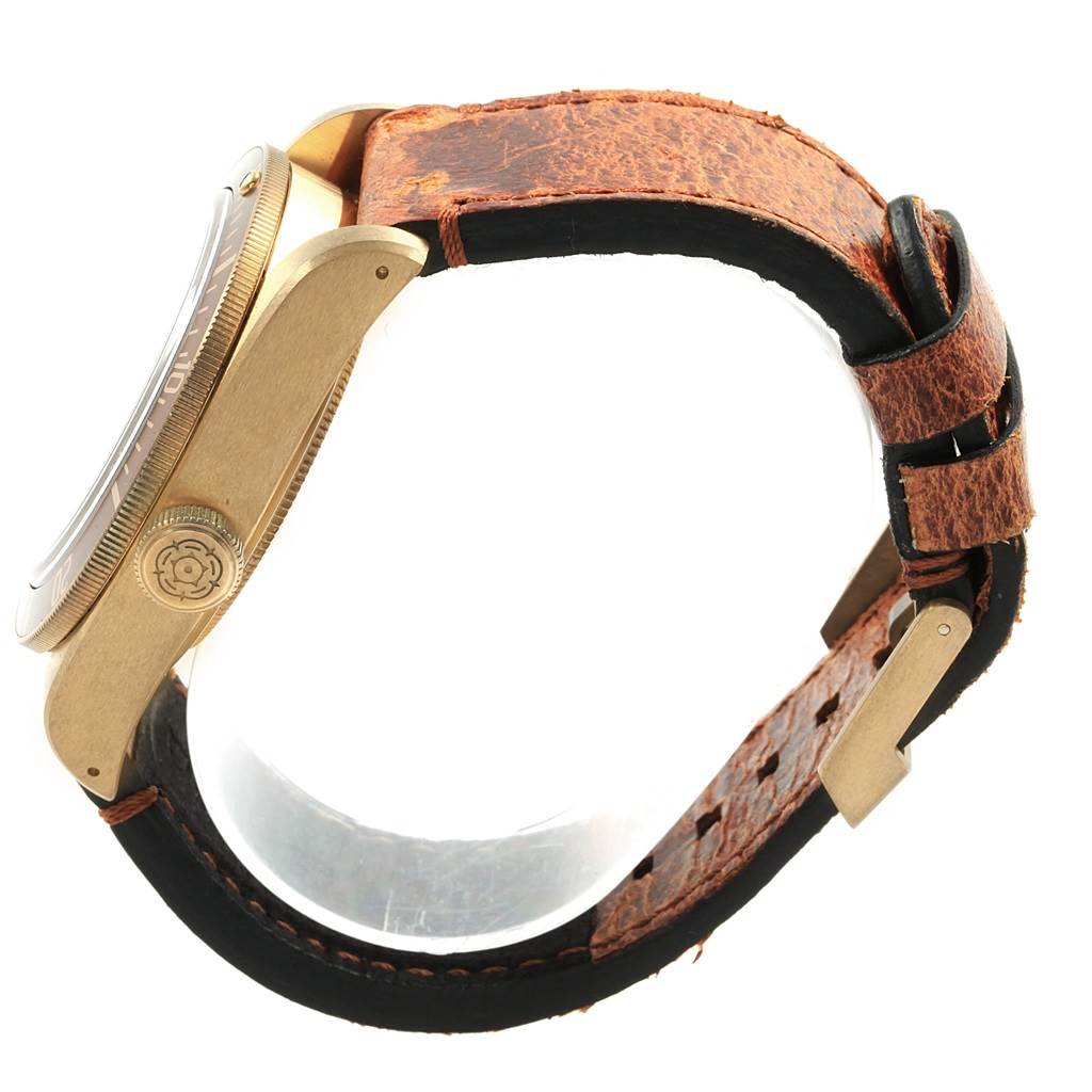 The image shows a side view of the Tudor Heritage Black Bay 79250 Men's Bronze Brown Dial 79250 Men's Bronze Brown Dial watch, highlighting its case, crown, and distressed leather strap.
