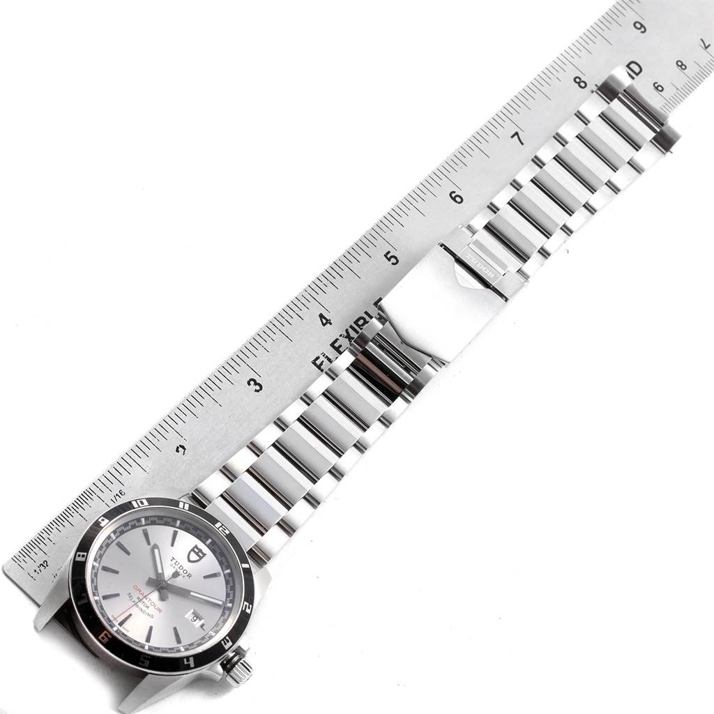 The image shows a Tudor Grantour 20500N Men's Stainless Steel Silver Dial 20500N Men's Stainless Steel Silver Dial watch laid flat with its metal bracelet extended next to a ruler.