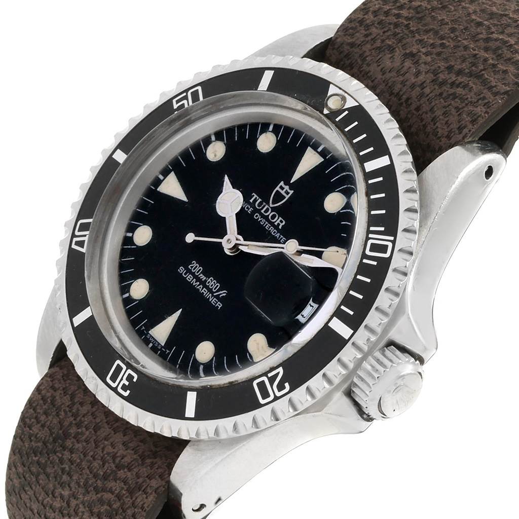 The Tudor Submariner 79090 Men's Stainless Steel Black Dial 79090 Men's Stainless Steel Black Dial watch is shown at an angle, highlighting its dial, bezel, crown, and textured strap.