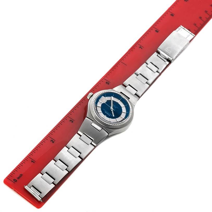 The image shows a top-down view of a Tudor Prince 9101/0 Men's Stainless Steel Silver Dial 9101/0 Men's Stainless Steel Silver Dial model watch, displaying its face and bracelet, with a red ruler for scale.