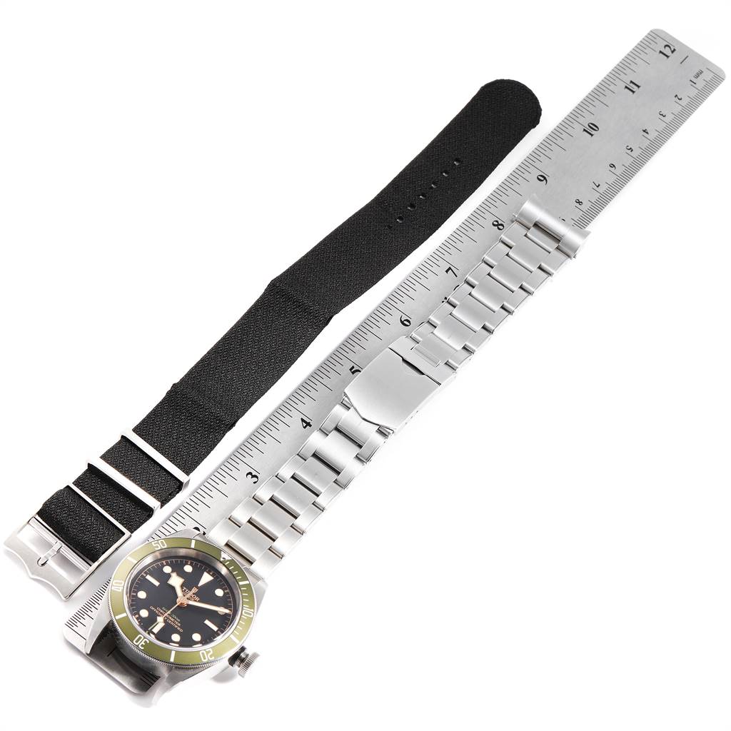 This image shows the Tudor Heritage Black Bay 79230G Men's Stainless Steel Black Dial 79230G Men's Stainless Steel Black Dial watch alongside a metal and a fabric strap, all measured against a ruler.