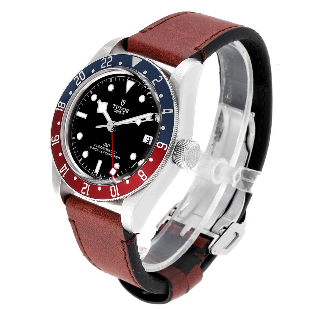 The image shows a Heritage Black Bay model by Tudor at an angled view, displaying the bezel, dial, and brown leather strap.