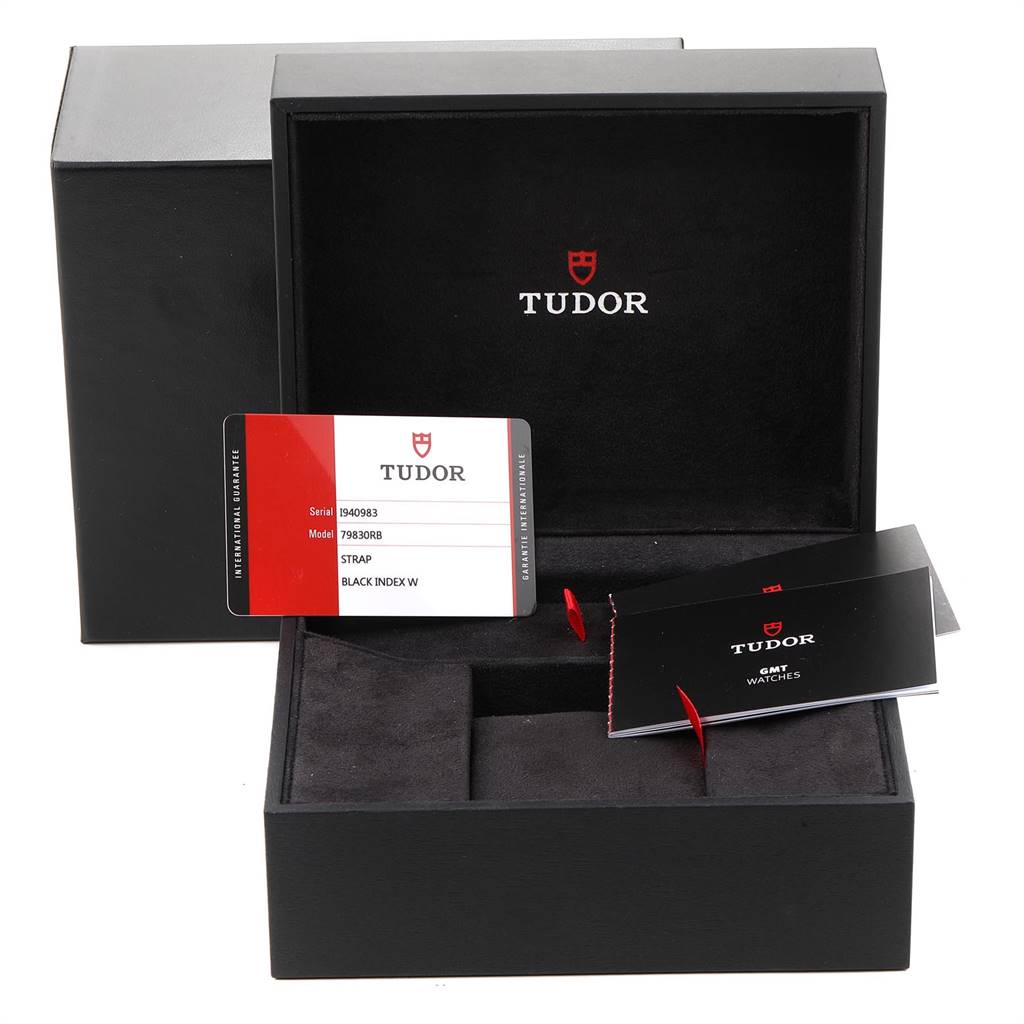 The image shows an open box of the Tudor Heritage Black Bay 79830RB Men's Stainless Steel Black Dial 79830RB Men's Stainless Steel Black Dial, with user manuals and a warranty card displayed.