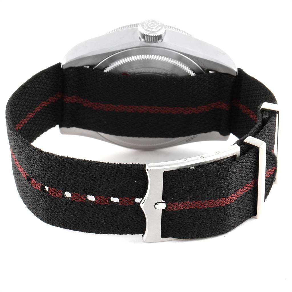 This image shows the back side of a Tudor Heritage Black Bay 79830RB Men's Stainless Steel Black Dial 79830RB Men's Stainless Steel Black Dial watch, featuring its case back, crown, and fabric strap with a metal buckle.