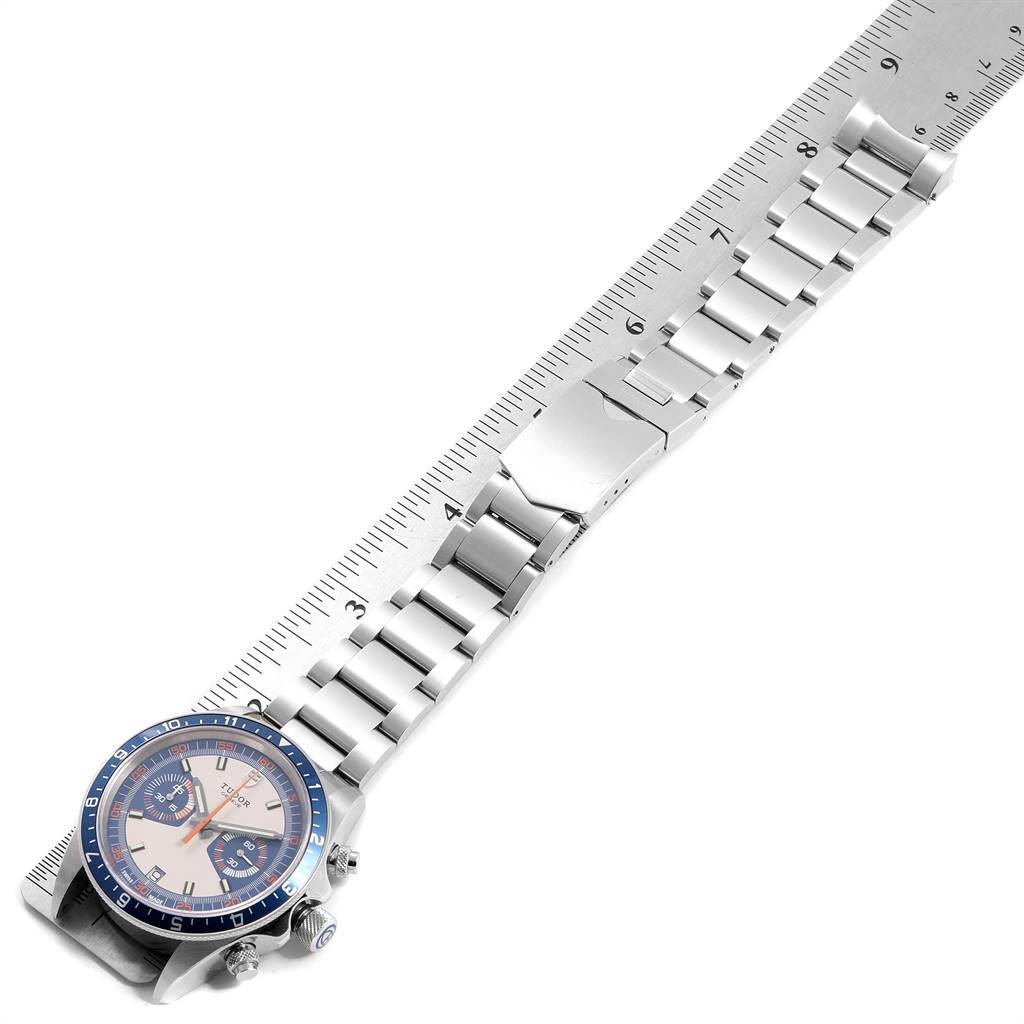 The image showcases a Tudor Heritage Chrono 70330B Men
s Stainless Steel Blue Dial 70330B Men
s Stainless Steel Blue Dial watch angled to display its face, stainless steel bracelet, and the deployment clasp.