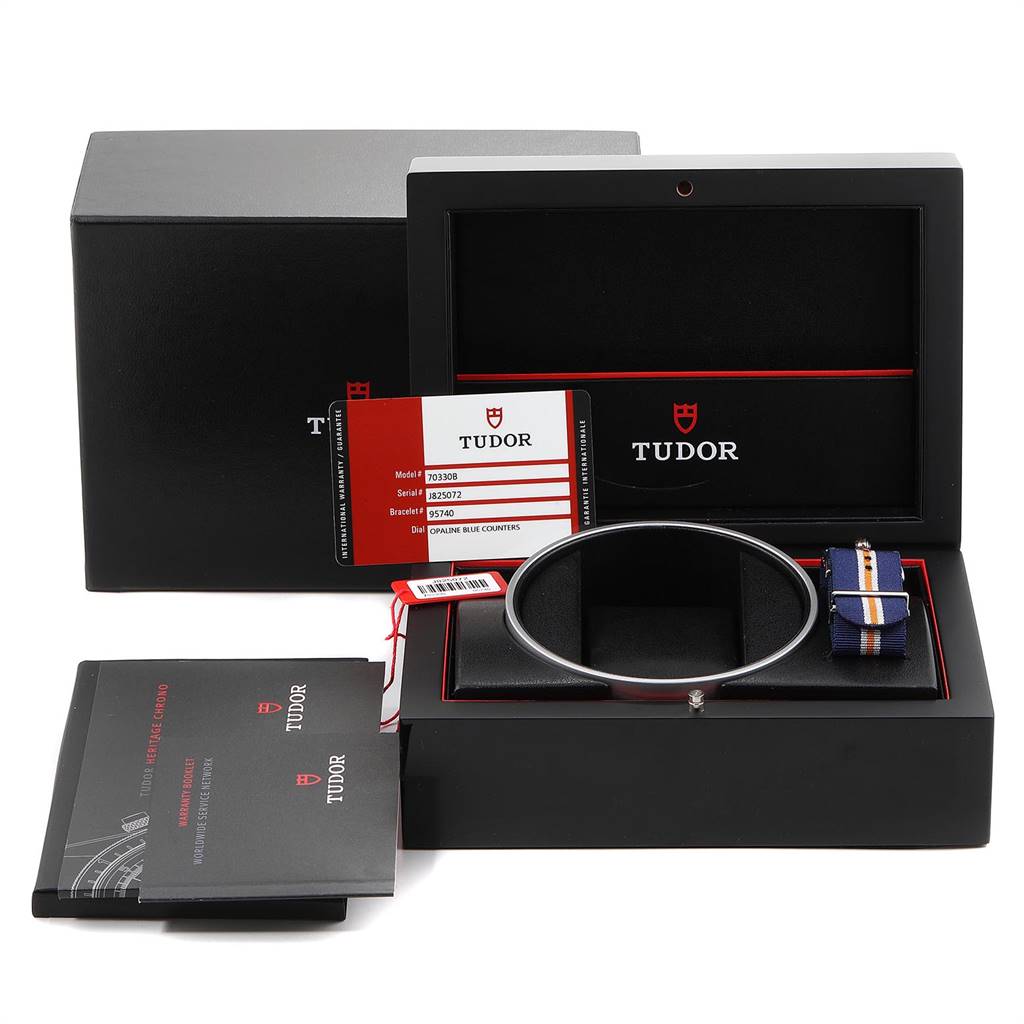 The image shows the Tudor Heritage Chrono 70330B Men
s Stainless Steel Blue Dial 70330B Men
s Stainless Steel Blue Dial packaging, including the box, strap, warranty card, and booklet, from a front angle.