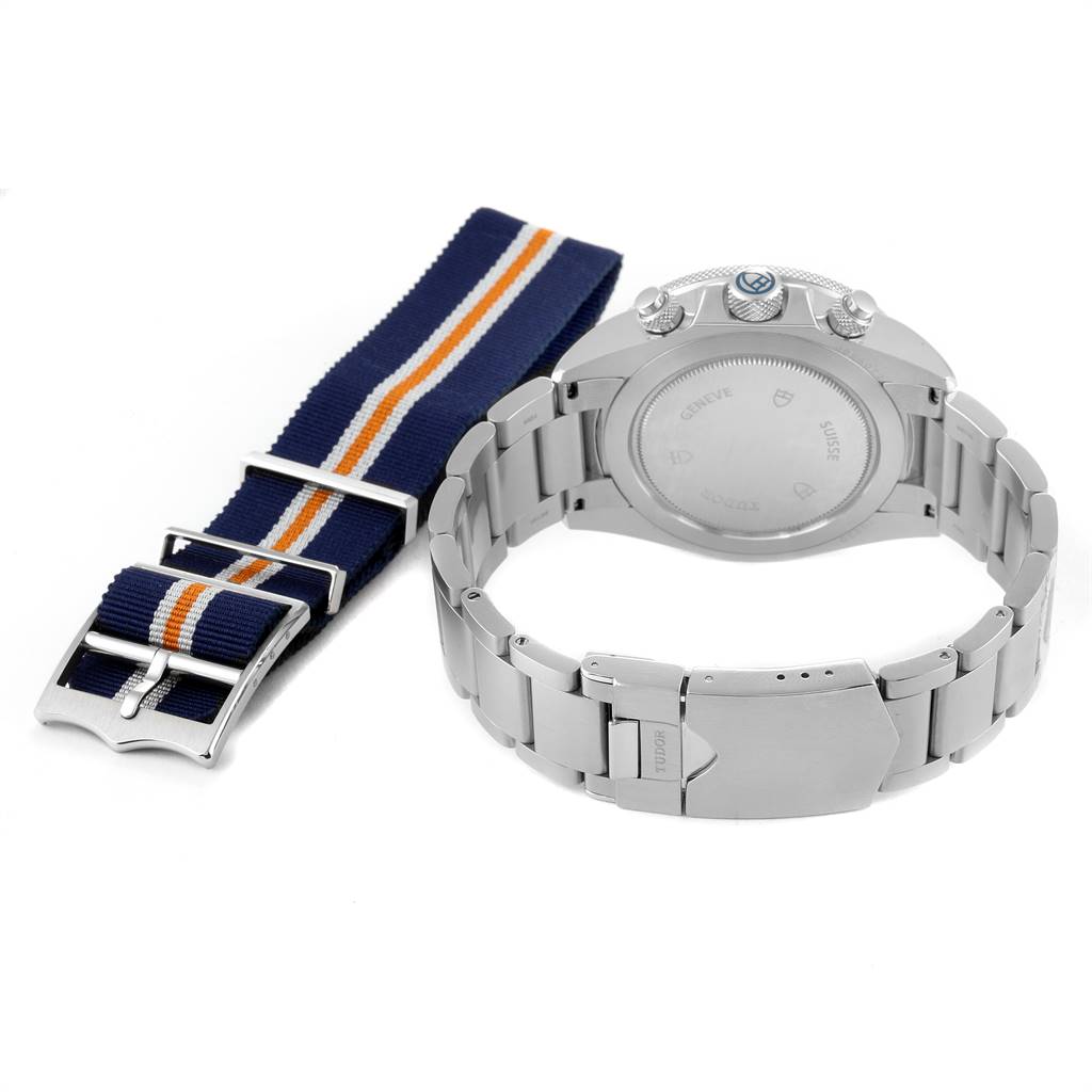 This image shows the back view of the Tudor Heritage Chrono 70330B Men
s Stainless Steel Blue Dial 70330B Men
s Stainless Steel Blue Dial watch including its stainless steel bracelet and a striped NATO strap.
