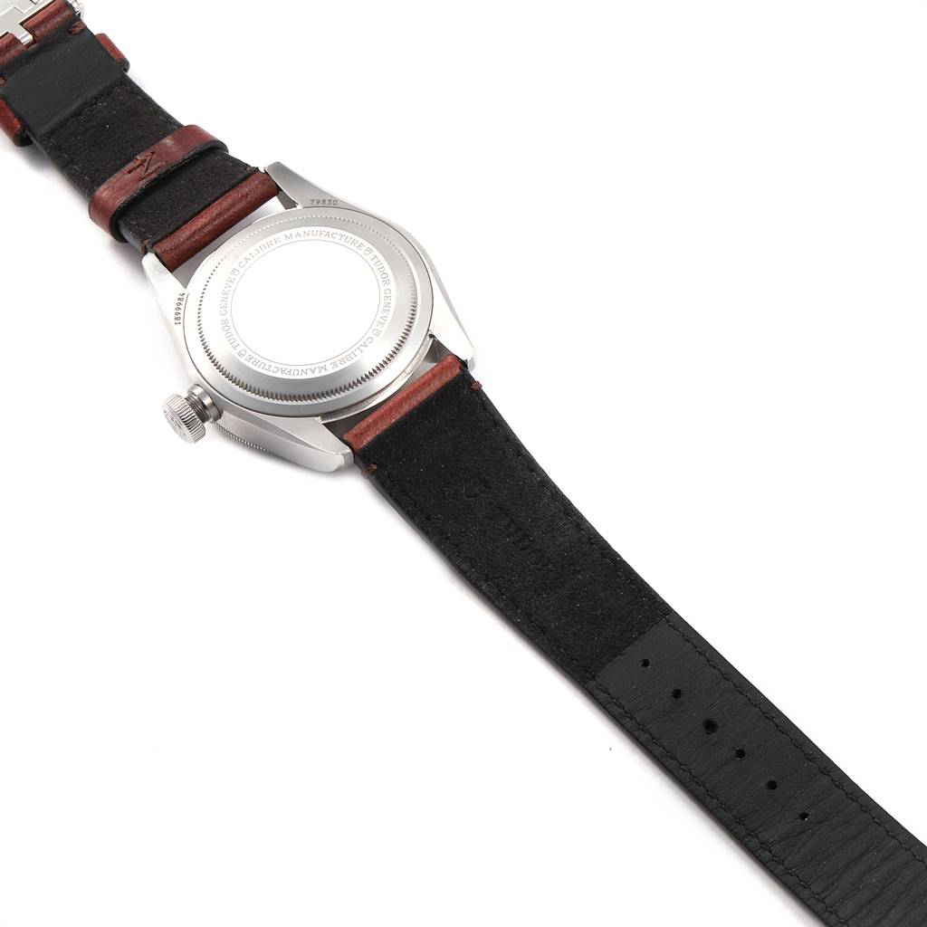 The image shows the backside of a Tudor Heritage Black Bay 79830RB Men's Stainless Steel Black Dial 79830RB Men's Stainless Steel Black Dial watch, highlighting the case back and leather straps.