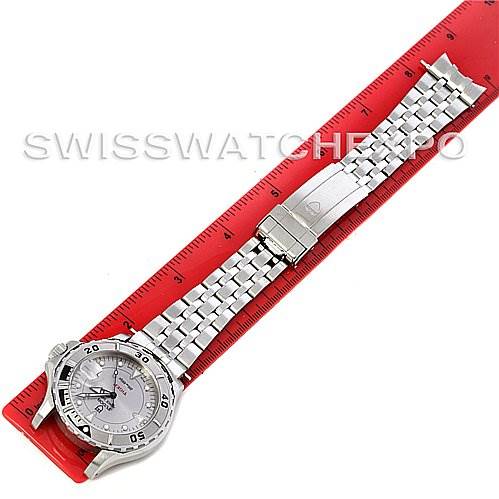 The image shows a top view of a Tudor Hydronaut 16220 Men's Stainless Steel Silver Dial 16220 Men's Stainless Steel Silver Dial watch with a metal bracelet on a red ruler.