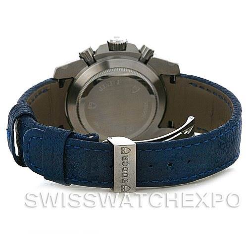 The image shows the back view of a Tudor Sport Chronograph 20300 Men's Stainless Steel Black Dial 20300 Men's Stainless Steel Black Dial watch, highlighting its blue strap and clasp.