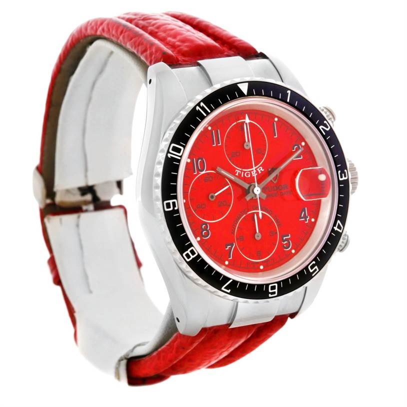The image shows a Tudor Tiger 79270 Men's Stainless Steel Red Dial 79270 Men's Stainless Steel Red Dial model watch with a red dial, chronograph subdials, and a red leather strap, viewed from an angled front side.