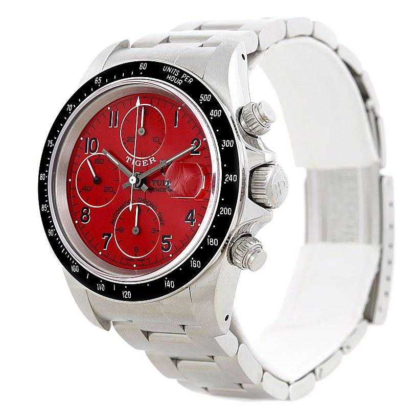 The Tudor Prince watch is shown from a three-quarter angle, displaying its red dial, chronograph subdials, and stainless steel bracelet.