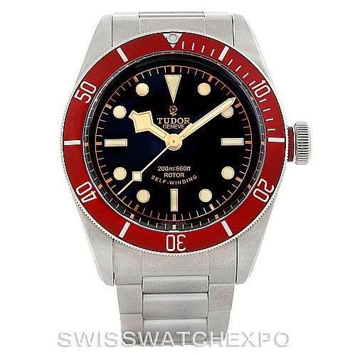 The image shows a front view of the Tudor Heritage Black Bay 79220R Men
s Stainless Steel Black Dial 79220R Men
s Stainless Steel Black Dial watch featuring a red bezel and a stainless steel bracelet.