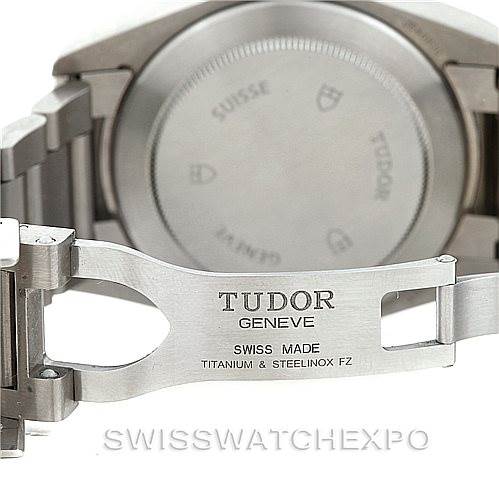 The image shows the clasp and case back of a Tudor Pelagos 25500TN Men's Titanium Black Dial 25500TN Men's Titanium Black Dial watch, emphasizing the "Tudor Geneve" and "Swiss Made" engravings.