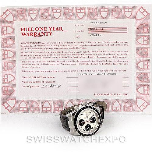 The image shows a Tudor Tiger 79260 Men's Stainless Steel White Dial 79260 Men's Stainless Steel White Dial model watch at an angled view with its warranty certificate in the background.