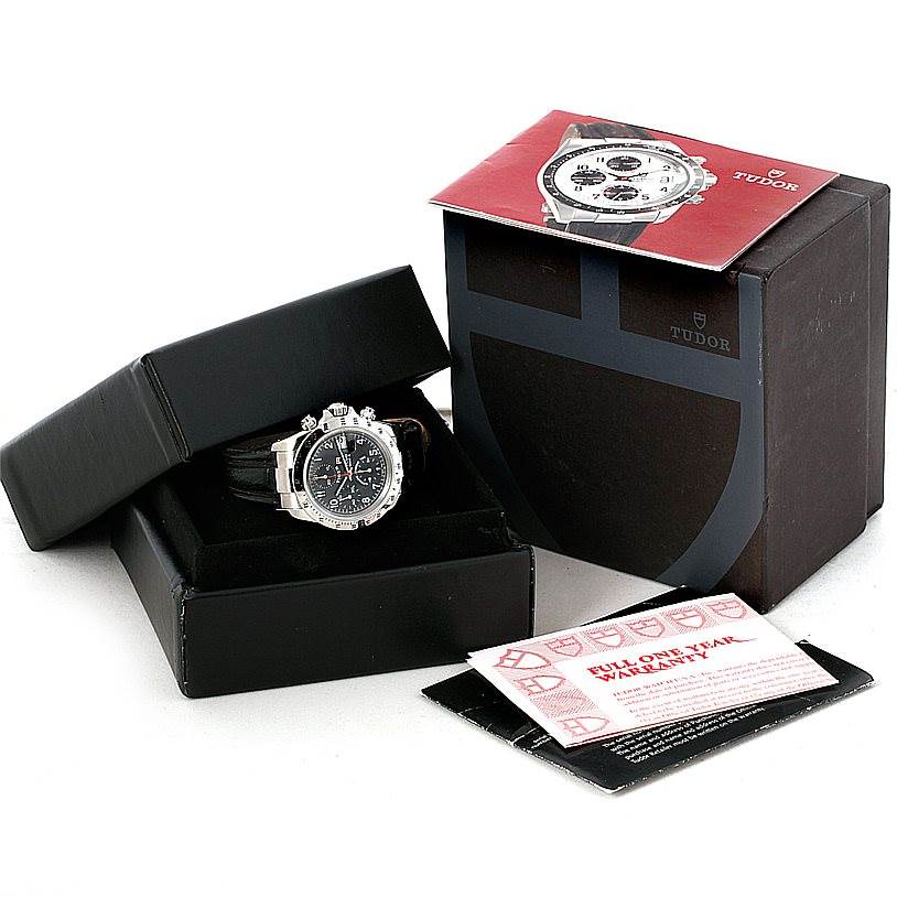 The Tudor Tiger 79280P Men's Stainless Steel Black Dial 79280P Men's Stainless Steel Black Dial watch is shown from a front angle in its box with packaging, manual, and warranty card.