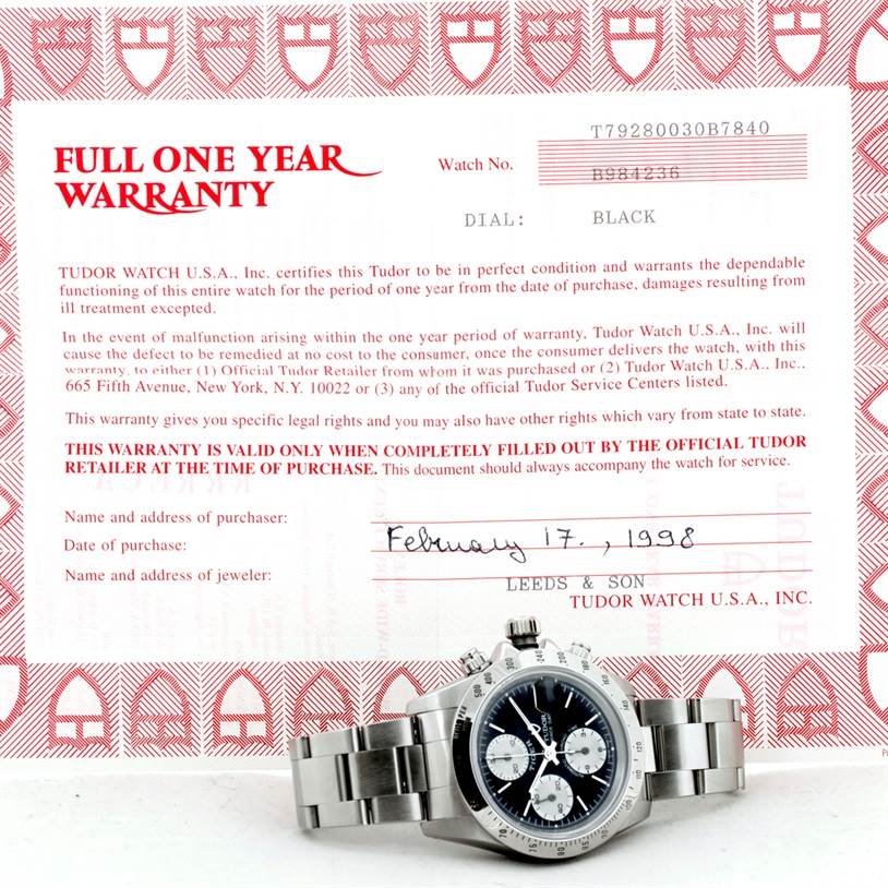 The Tudor Prince watch is shown at a slight side angle, with the bracelet and face visible in front of a warranty certificate.