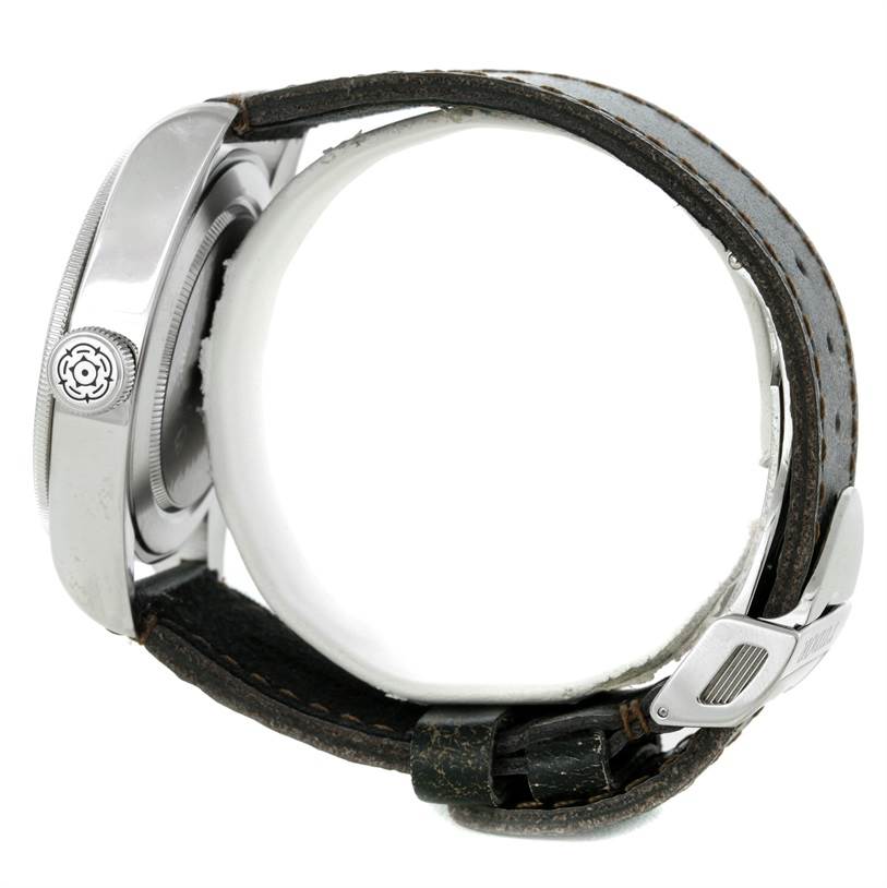 The image shows a side view of the Tudor Heritage Black Bay 79220R Men's Stainless Steel Black Dial 79220R Men's Stainless Steel Black Dial watch, highlighting the crown and leather strap with a clasp.