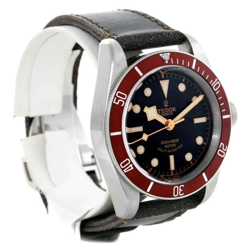 The Tudor Heritage Black Bay 79220R Men's Stainless Steel Black Dial 79220R Men's Stainless Steel Black Dial watch is shown at a front-left angle, displaying its dial, bezel, and leather strap.
