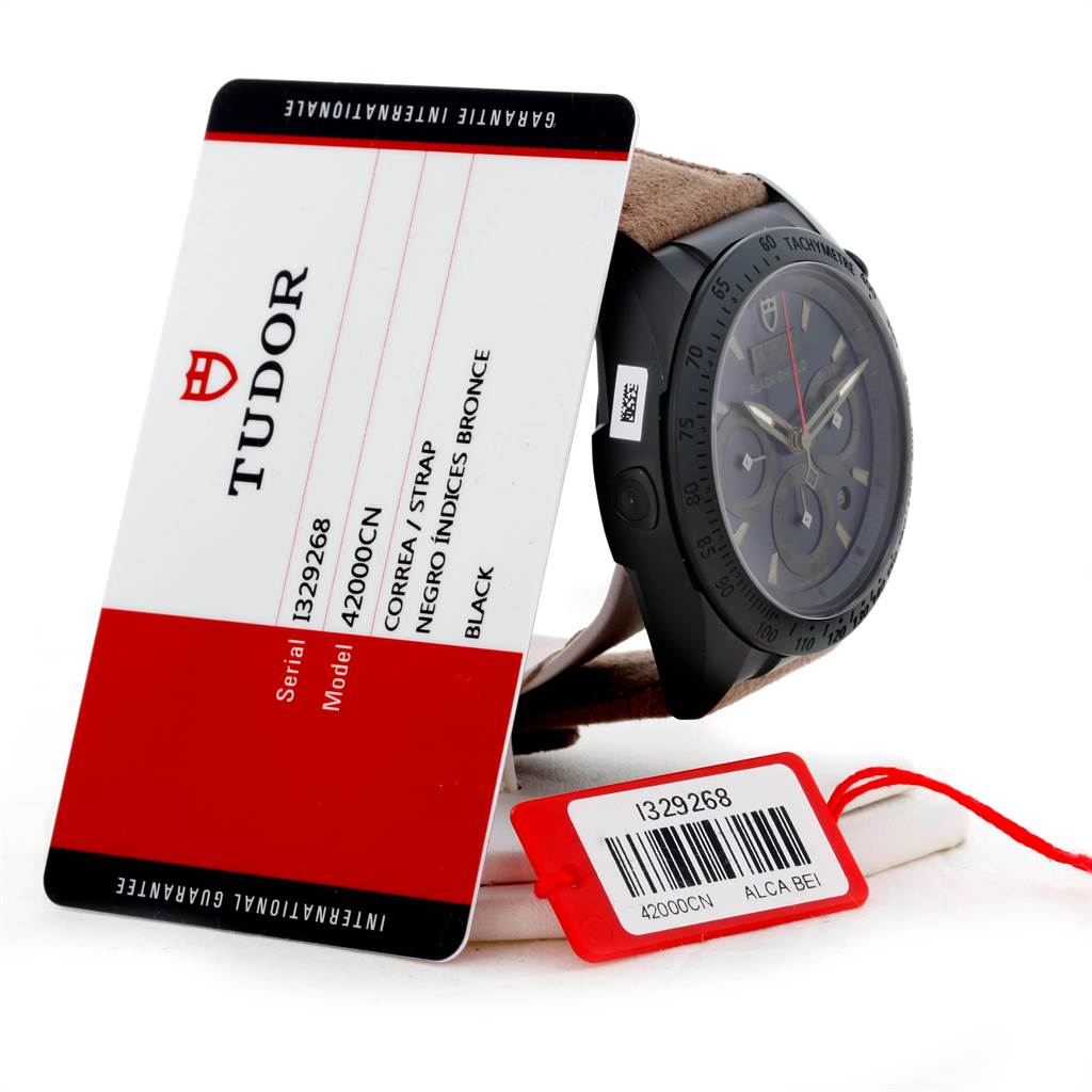 The Tudor Fastrider 42000CN Men's Stainless Steel Black Dial 42000CN Men's Stainless Steel Black Dial watch is shown at an angle, with the dial, side buttons, and attached hangtags visible.