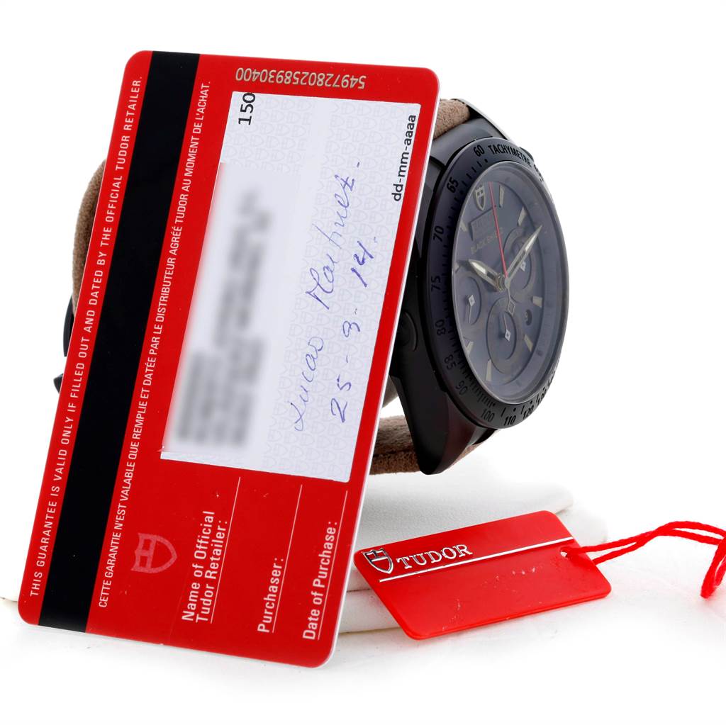 The Tudor Fastrider 42000CN Men's Stainless Steel Black Dial 42000CN Men's Stainless Steel Black Dial watch is displayed from a side angle with warranty cards and a red Tudor tag.