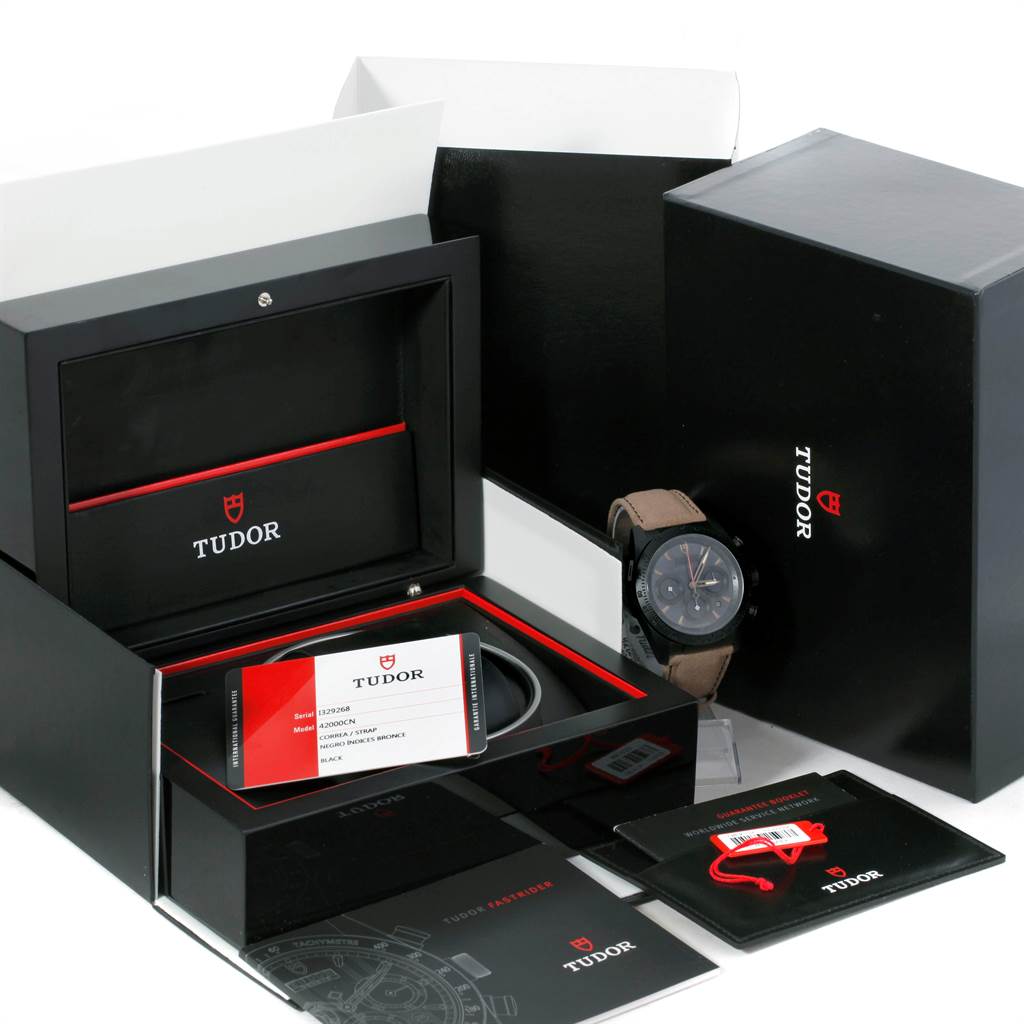 The image shows a Tudor Fastrider 42000CN Men's Stainless Steel Black Dial 42000CN Men's Stainless Steel Black Dial watch with packaging, certification cards, and manuals from an angled top-down view.