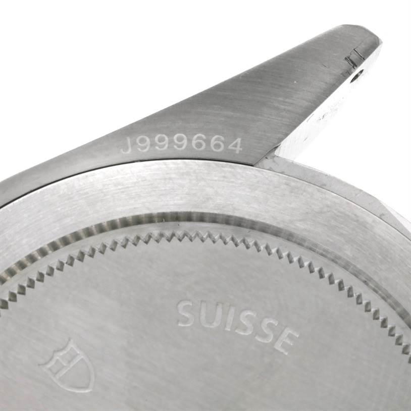 This is a close-up of the back casing and lug of a Tudor Heritage Black Bay 79220 Men's Stainless Steel Black Dial 79220 Men's Stainless Steel Black Dial watch, displaying part of the serial number and "Suisse" engraving.