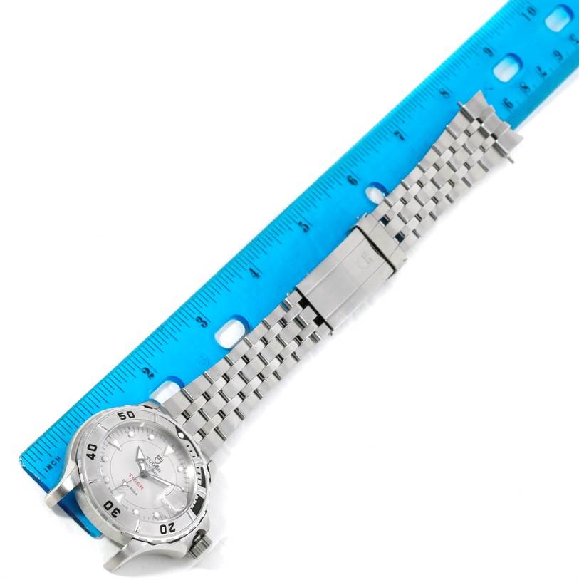 The Tudor Hydronaut 89190 Men's Stainless Steel Silver Dial 89190 Men's Stainless Steel Silver Dial watch is shown lying flat next to a blue ruler, displaying the face, bezel, and bracelet.