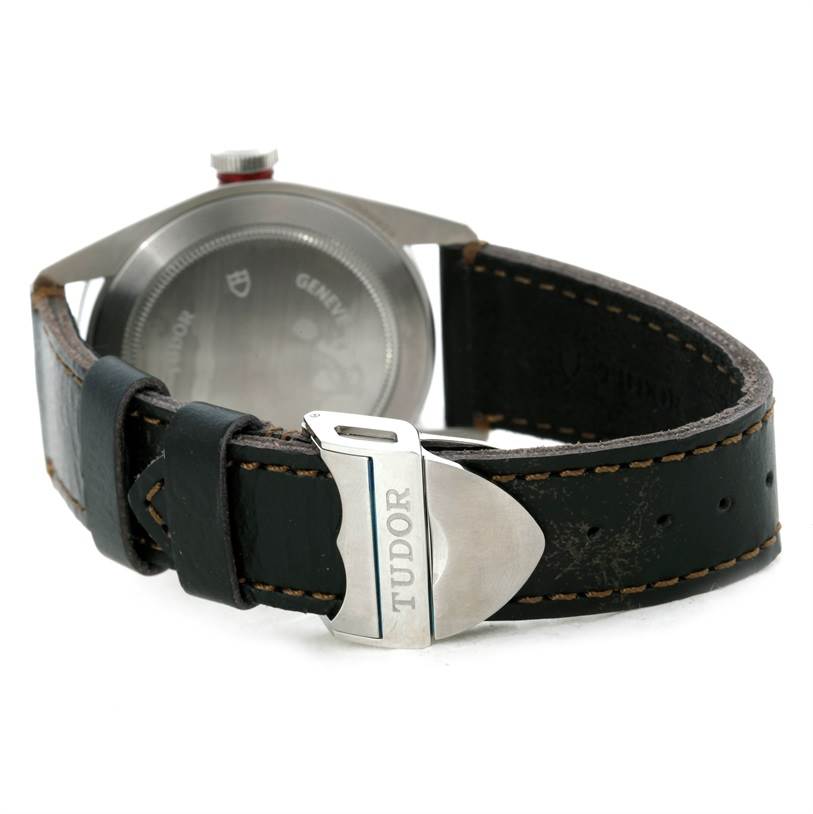The image shows the rear angle of the Tudor Heritage Black Bay 79220R Men
s Stainless Steel Black Dial 79220R Men
s Stainless Steel Black Dial watch, focusing on the back case and leather strap with Tudor branding.