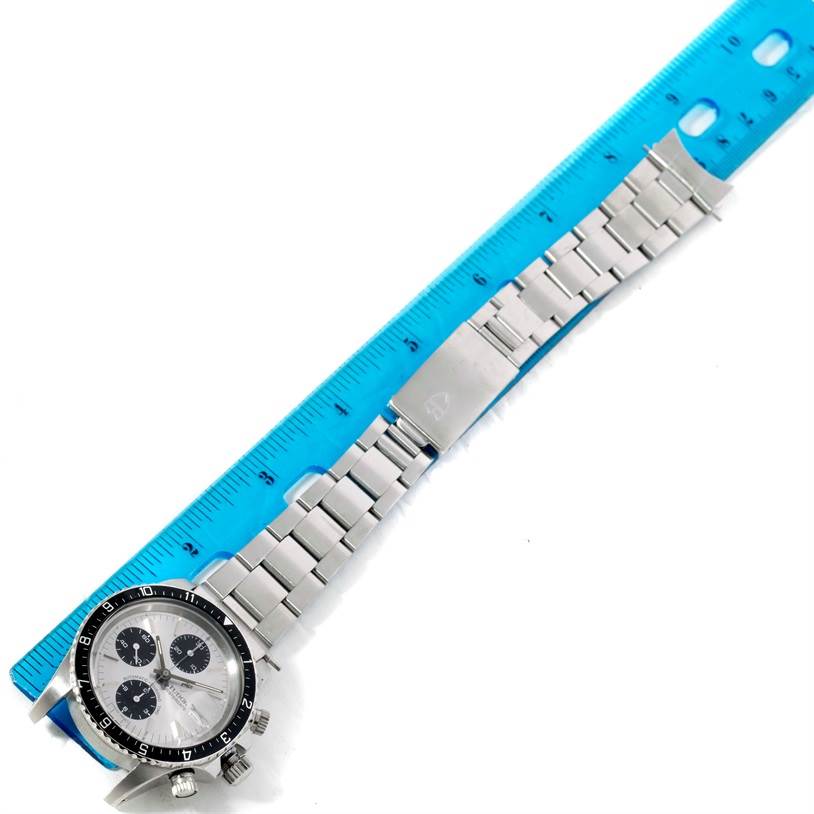 This image shows a Tudor Big Block 79170 Men's Stainless Steel Silver Dial 79170 Men's Stainless Steel Silver Dial watch laid flat next to a blue ruler, highlighting its full length and bracelet.