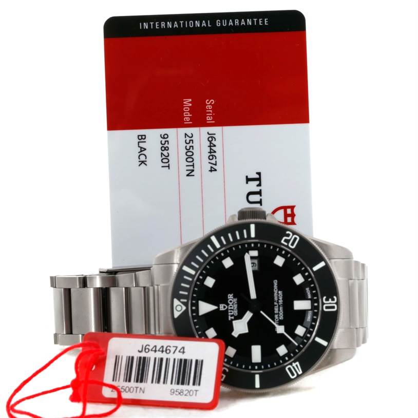 The image shows a Tudor Pelagos 25500TN Men's Titanium Black Dial 25500TN Men's Titanium Black Dial watch from a front angle with its identification tags and warranty card.