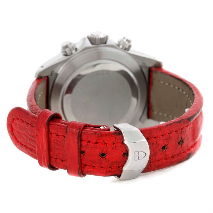 The Tudor Prince model watch is shown from the back, highlighting its case and red leather strap with a clasp.