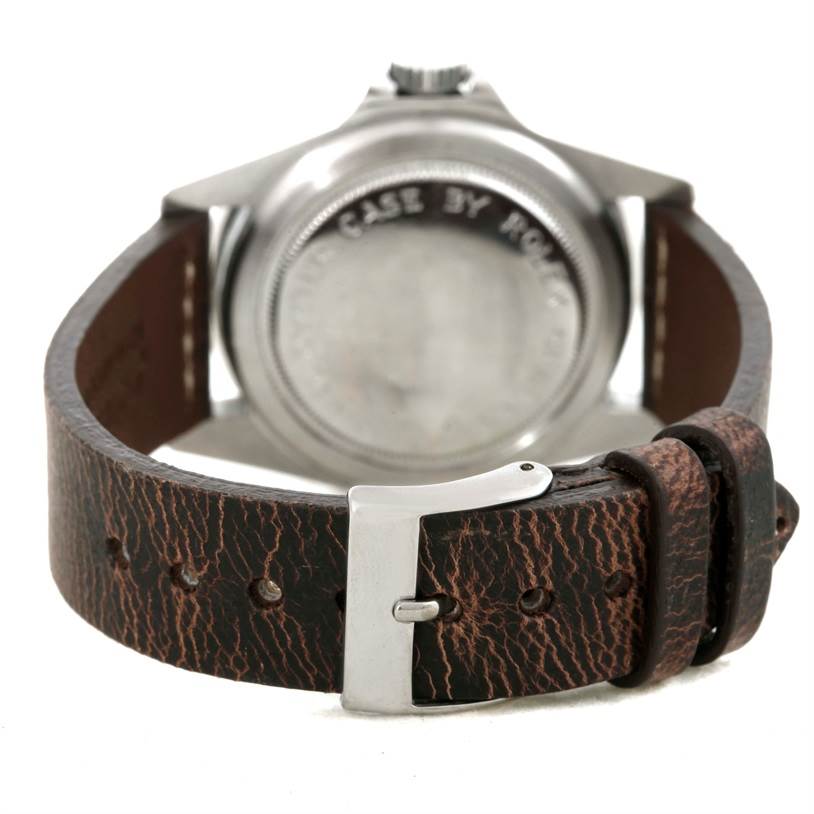 The image shows the back of a Tudor Submariner 7016 Men's Stainless Steel Black Dial 7016 Men's Stainless Steel Black Dial watch with a close-up of the case, crown, and leather strap with a buckle.