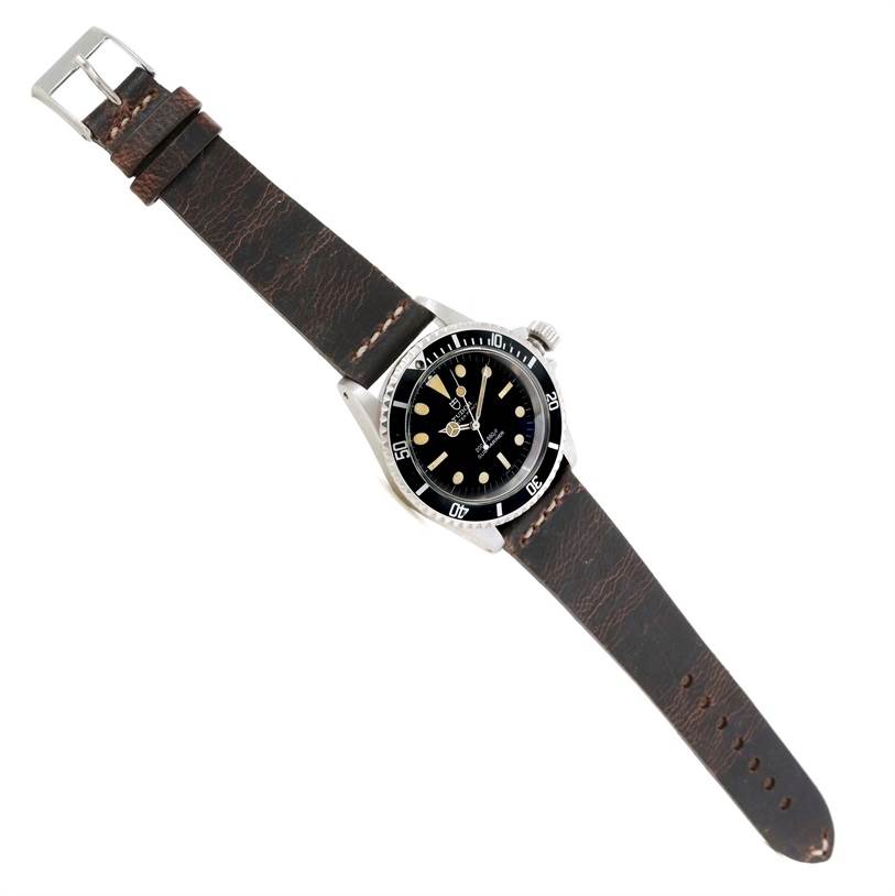 This image shows a Tudor Submariner 7016 Men's Stainless Steel Black Dial 7016 Men's Stainless Steel Black Dial watch at a top-down angle, with its black dial, bezel, and brown leather strap visible.
