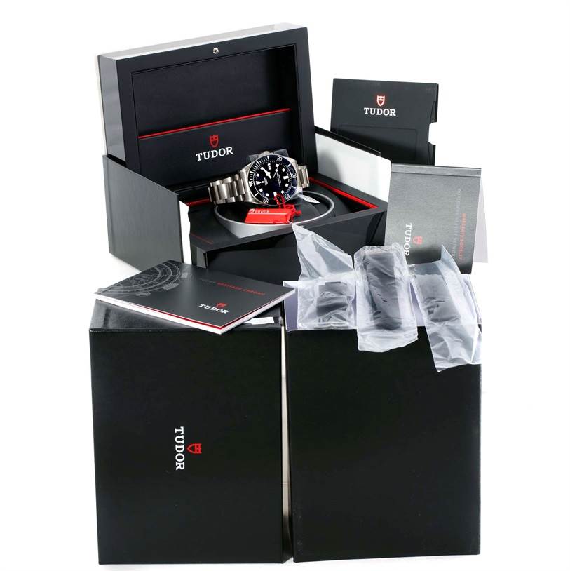 The Tudor Pelagos 25500TN Men's Titanium Black Dial 25500TN Men's Titanium Black Dial watch is shown at an angle inside its open box, along with manuals and additional accessories.
