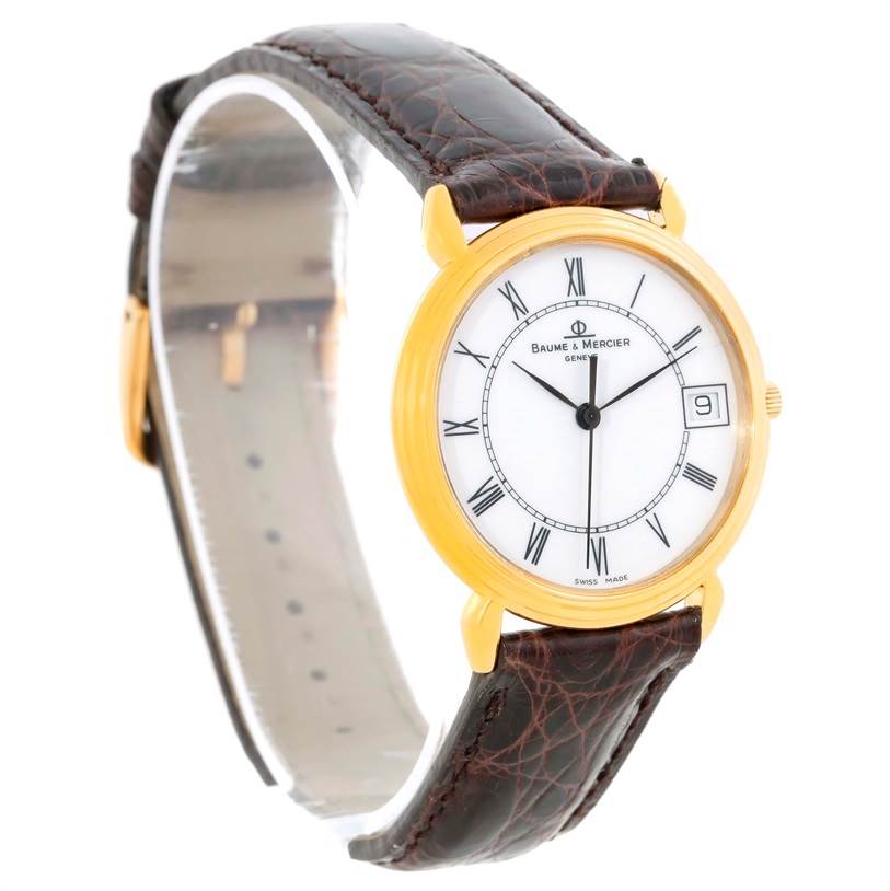 The Baume & Mercier Classima 15163 Men's Yellow Gold White Dial 15163 Men's Yellow Gold White Dial watch is shown from a three-quarter front angle, highlighting the dial, bezel, and leather strap.