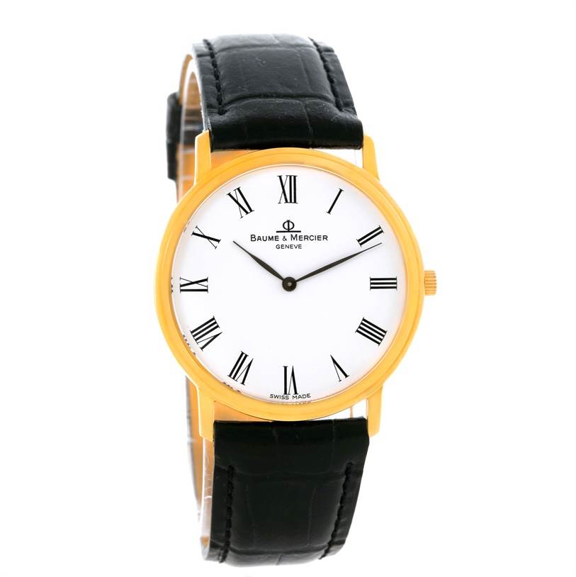 The image shows a front view of the Baume & Mercier Classima MV045094 Men's Yellow Gold White Dial MV045094 Men's Yellow Gold White Dial watch, featuring a gold case, white dial, Roman numerals, and black leather strap.