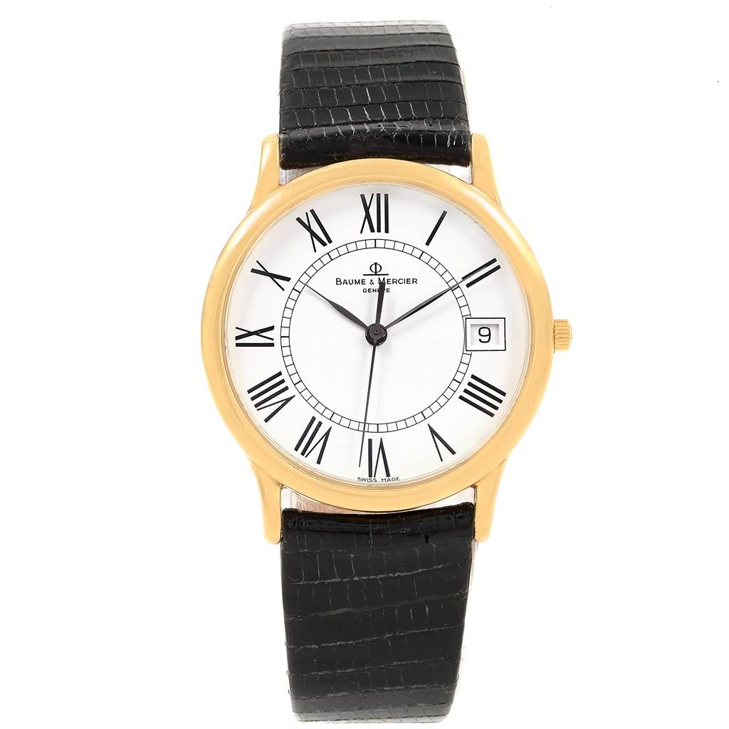 The image shows a front view of a Baume 
Mercier Classima MV045077 Men
s Yellow Gold White Dial MV045077 Men
s Yellow Gold White Dial watch with a gold case, Roman numerals, and black leather strap.