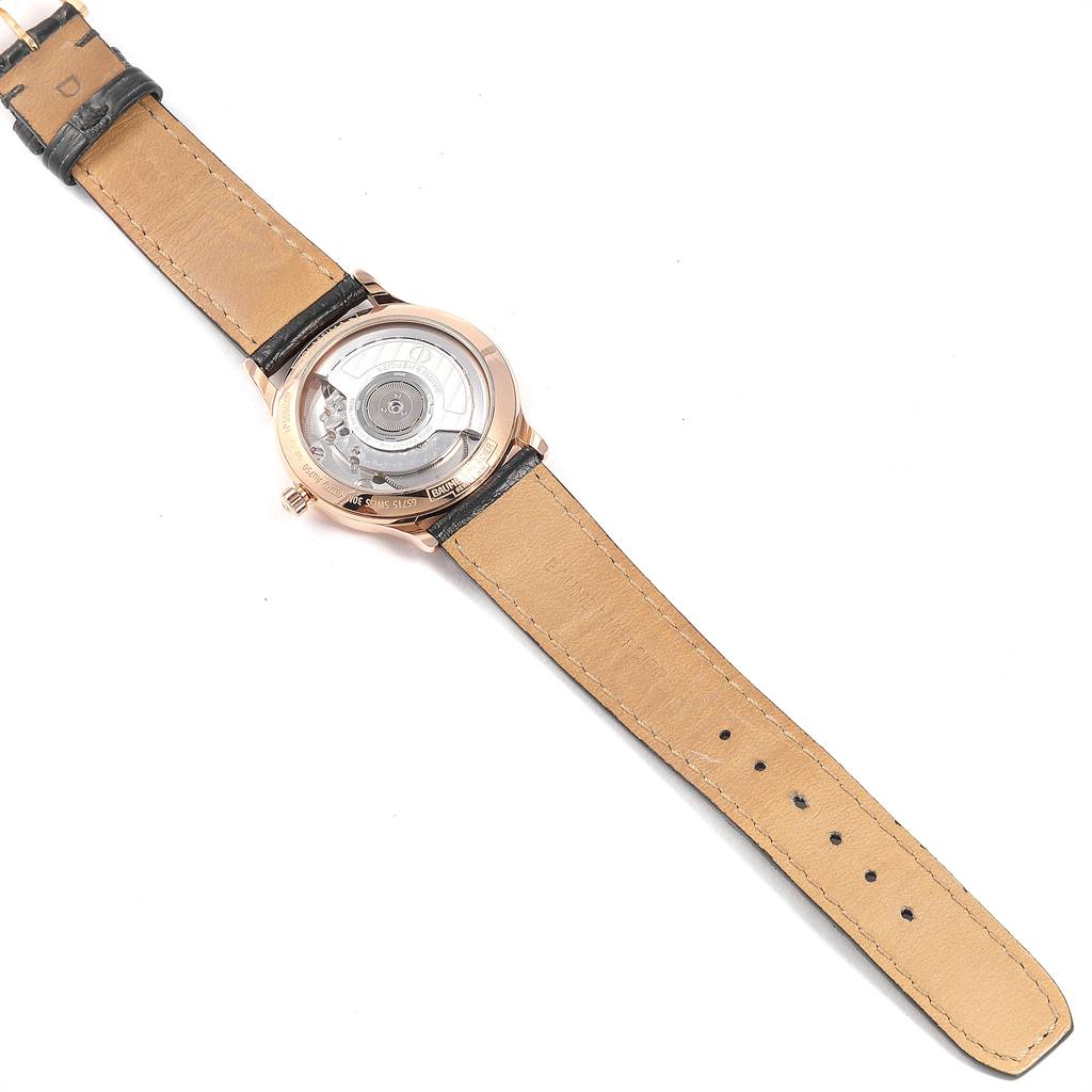 The image shows the back view of the Baume & Mercier Classima 10077 Men's Rose Gold Mother of Pearl Dial 10077 Men's Rose Gold Mother of Pearl Dial watch, displaying its leather strap and visible internal mechanism.