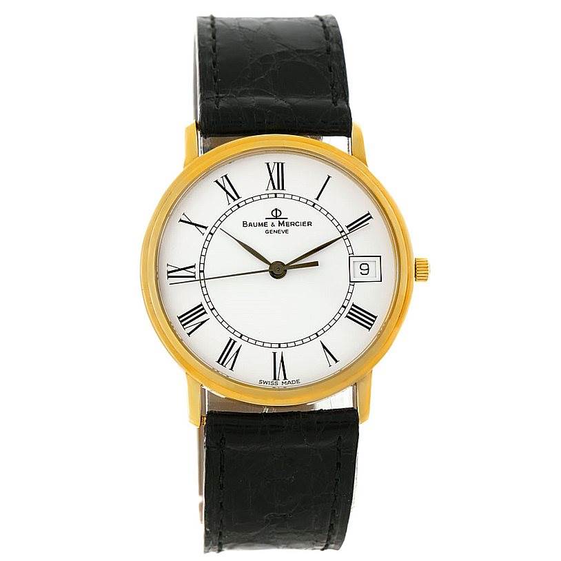 The Baume & Mercier Classima 95712 Men's Yellow Gold White Dial 95712 Men's Yellow Gold White Dial watch is shown from a front angle, displaying its dial, Roman numerals, date window, and black strap.