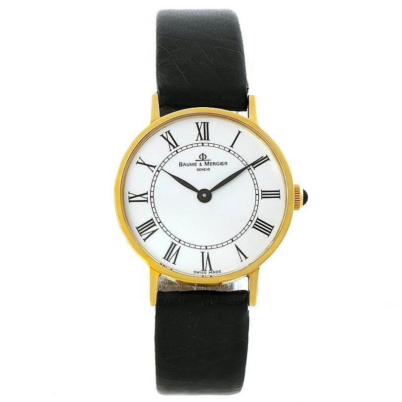 The image shows a front view of the Baume & Mercier Classima 55121 Men's Yellow Gold White Dial 55121 Men's Yellow Gold White Dial watch, featuring a white dial, Roman numerals, and a black leather strap.
