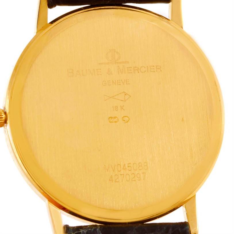 This image shows the back of the gold-colored Baume & Mercier Classima MV045088 Men's Yellow Gold White Dial MV045088 Men's Yellow Gold White Dial watch, displaying the brand engraving and serial numbers.