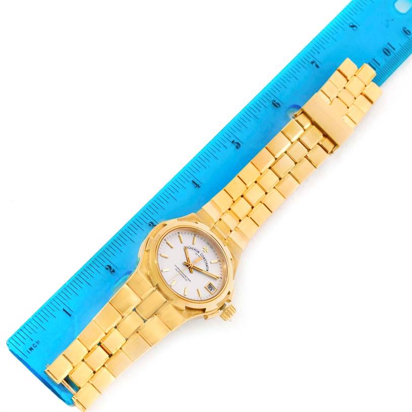 The Vacheron Constantin Overseas 42050/423J Men's Yellow Gold Silver Dial 42050/423J Men's Yellow Gold Silver Dial model watch is shown from an overhead angle, alongside a blue ruler for scale.