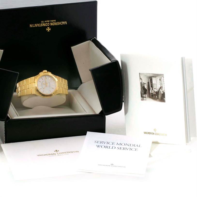 The Vacheron Constantin Overseas 42050/423J Men's Yellow Gold Silver Dial 42050/423J Men's Yellow Gold Silver Dial watch is shown in its open box, along with accompanying documents and manuals.