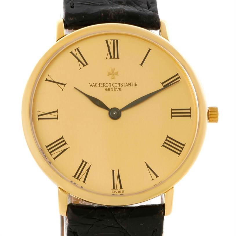 The image shows a front view of a Vintage Vacheron Constantin watch with a gold case, Roman numerals, hands, and a black leather strap.