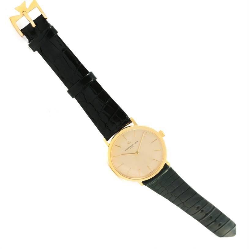 The image displays a Vintage Vacheron Constantin watch with a gold case and a black leather strap at an angled top-down view.